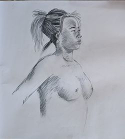 A charcoal sketch of a woman facing side-on with her chest out proudly